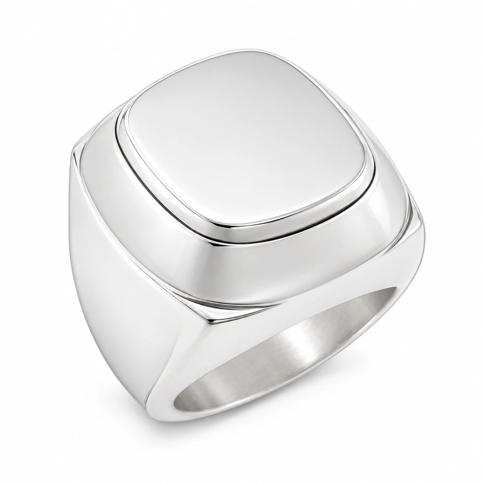 Anillo CMS-AN-1021 de apariencia plateada, cabeza cojín rectangular elevada de metal liso, sin piedras, sobre fondo blanco.