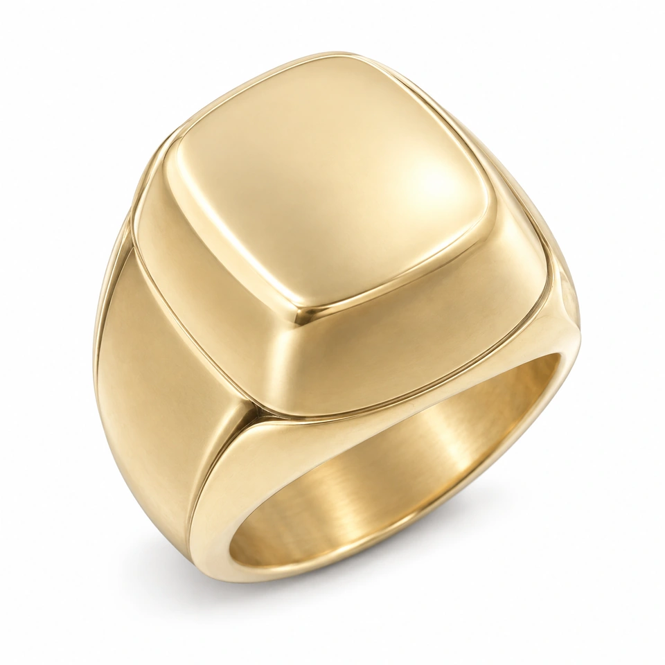 Anillo CMS-AN-1032 de apariencia dorada, cabeza cojín amplio de metal liso, sin piedras, sobre fondo blanco.
