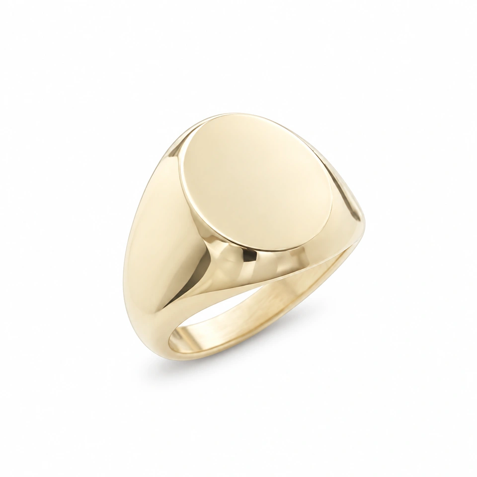 Anillo CMS-AN-1070 de apariencia dorada, cabeza ovalada compacta de metal liso, sin piedras, sobre fondo blanco.