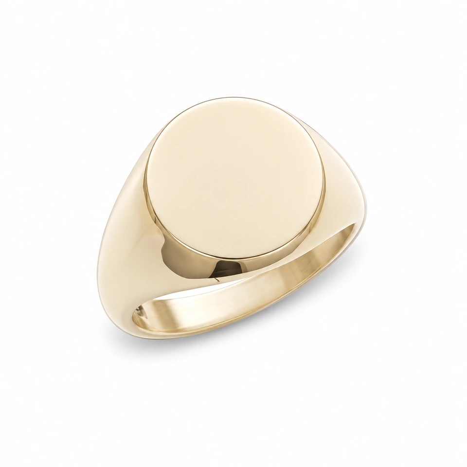 Anillo CMS-AN-1074 de apariencia dorada, cabeza circular plana de metal liso, sin piedras, sobre fondo blanco.
