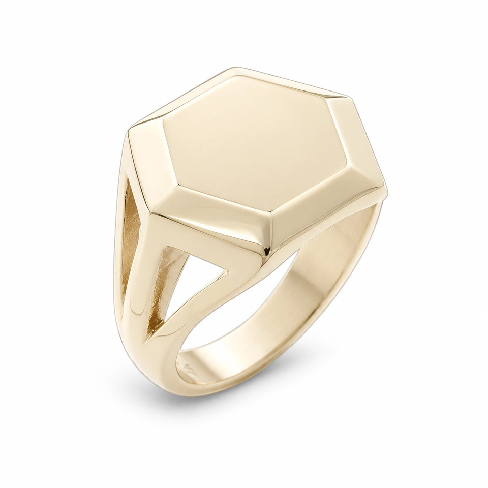 Anillo CMS-AN-1089 de apariencia dorada, cabeza hexagonal compacta de metal liso, sin piedras, sobre fondo blanco.