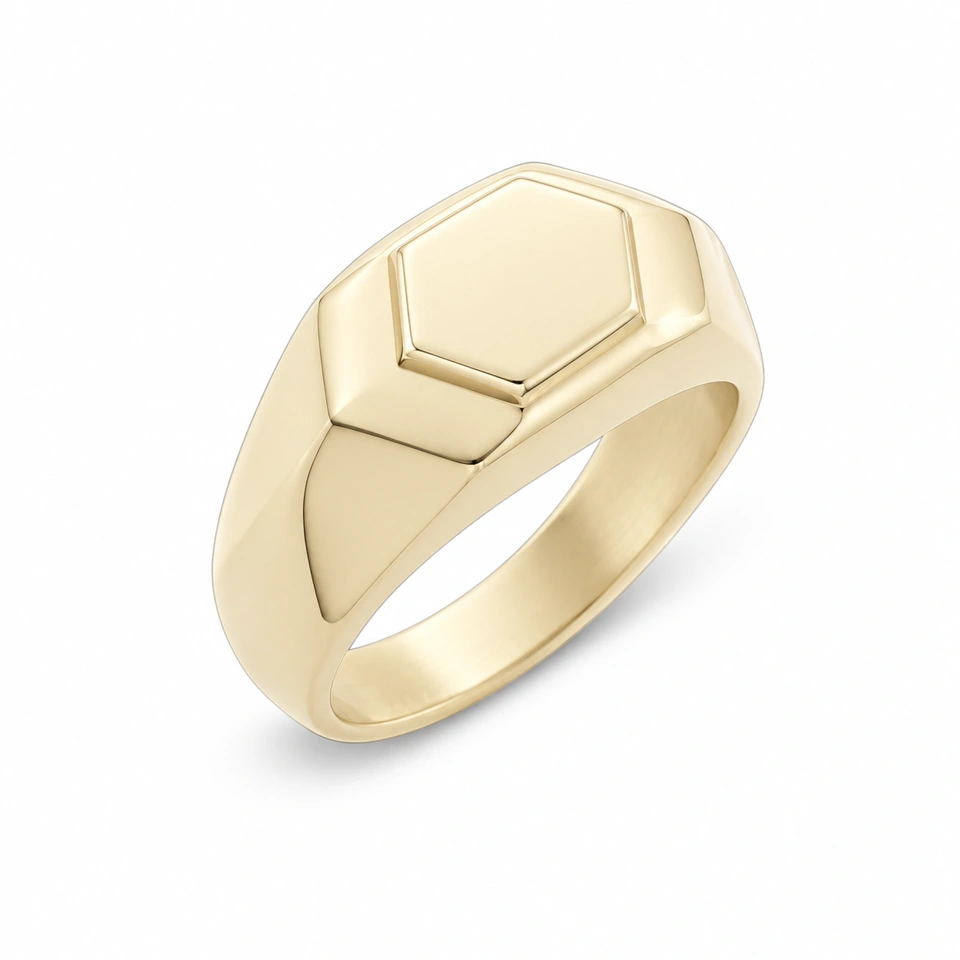 Anillo CMS-AN-1105 de apariencia dorada, cabeza hexagonal de metal liso, sin piedras, sobre fondo blanco.